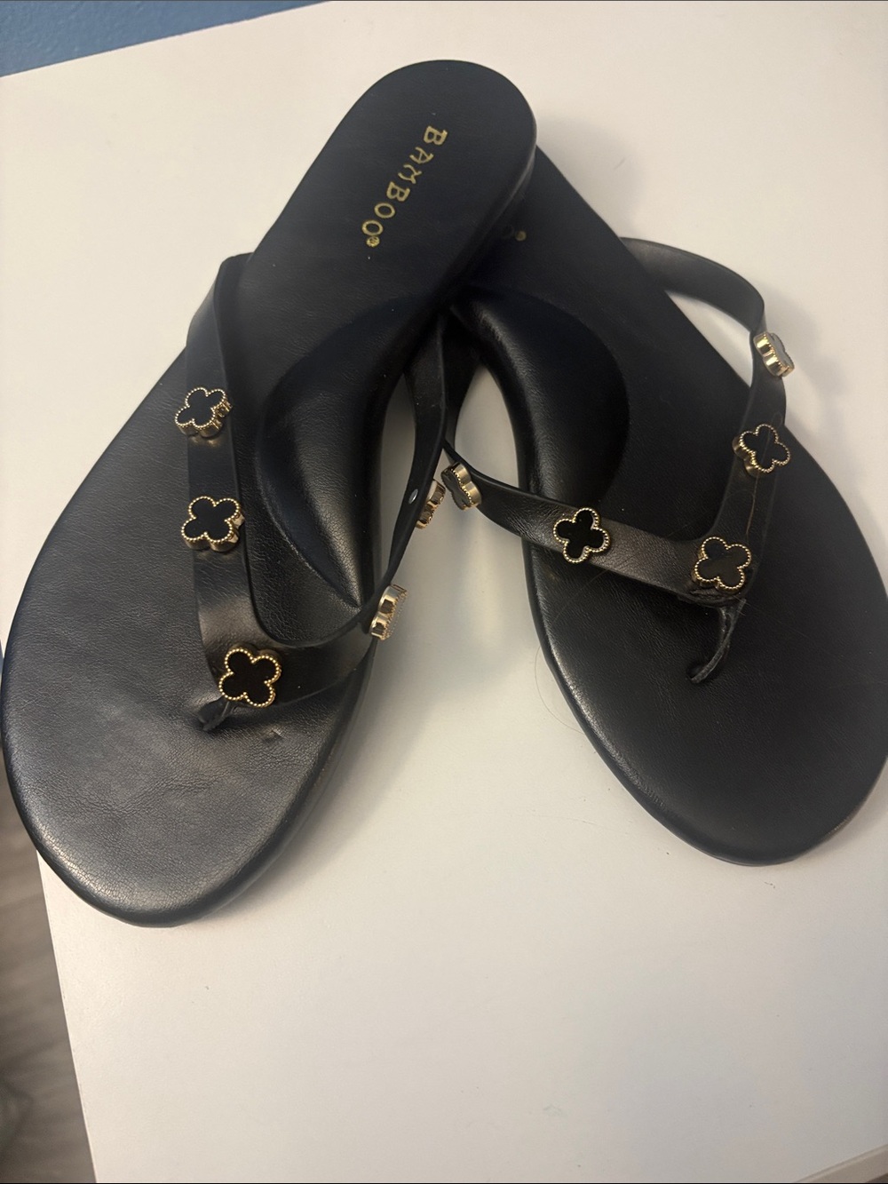BAMBOO Black Flip-Flop Sandals with Gold Flower Accents